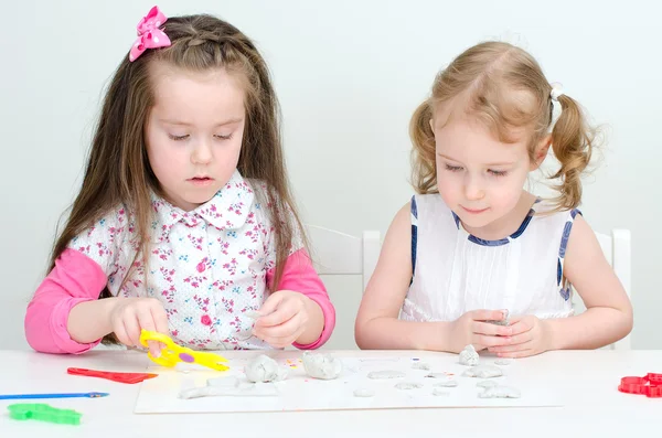 Dvě malé holčičky vyřezávání pomocí hlíny — Stock fotografie