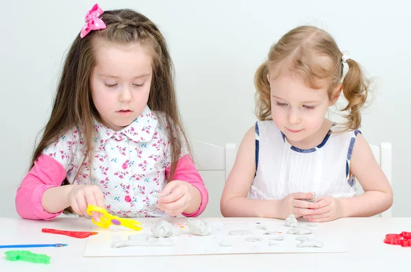 Twee kleine meisjes beeldhouwen met behulp van klei — Stockfoto