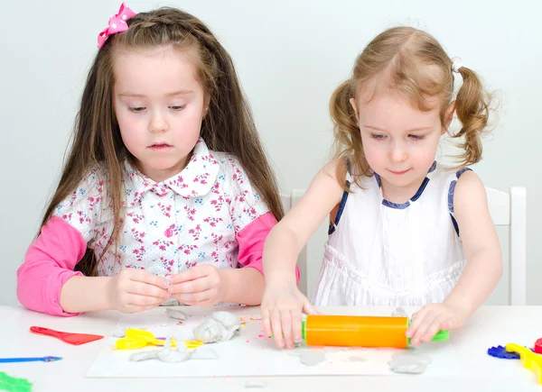 Two little girls sculpting using clay — Stock Photo, Image