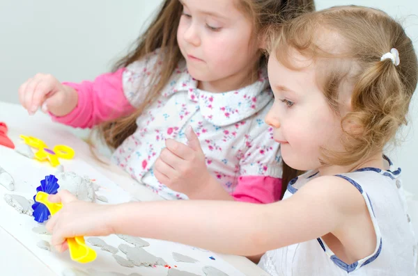 Twee kleine meisjes beeldhouwen met behulp van klei — Stockfoto