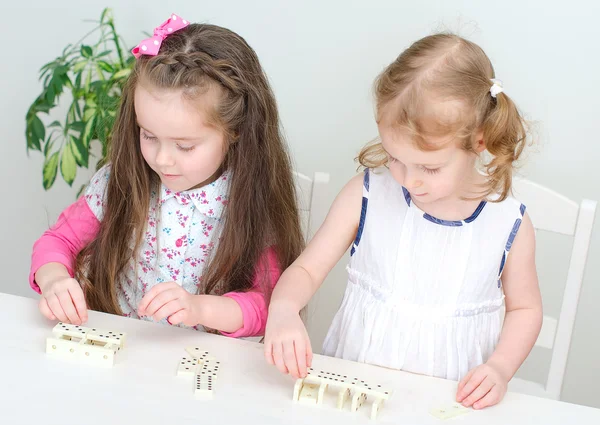 玩多米诺骨牌在桌上的两个小女孩 — 图库照片