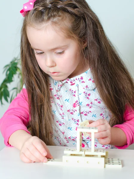 Menina jogando dominó na mesa — Fotografia de Stock