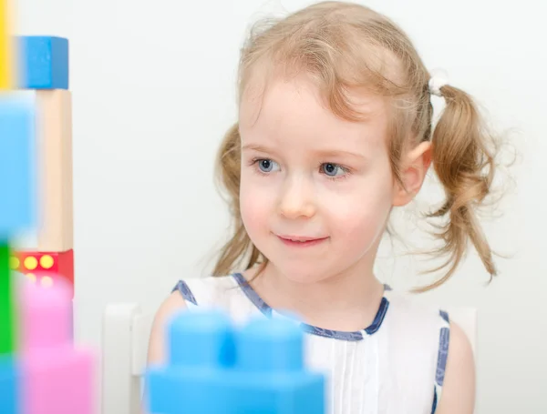 Retrato de niña pequeña cerca de bloques bulding — Foto de Stock