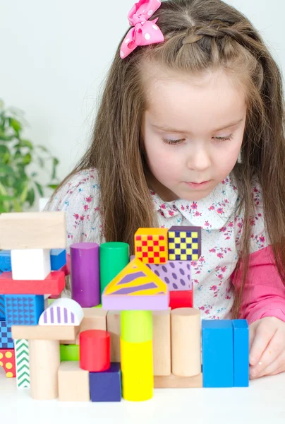 Liten flicka spelar med byggstenar — Stockfoto