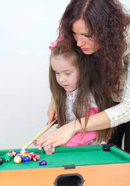 Madre enseñando hija jugar al billar — Foto de Stock