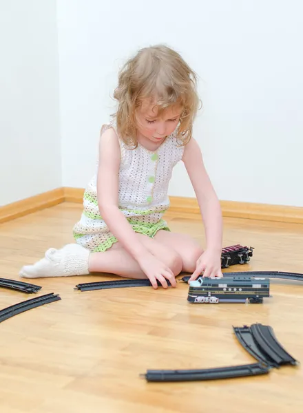 Jolie petite fille jouant avec le chemin de fer — Photo