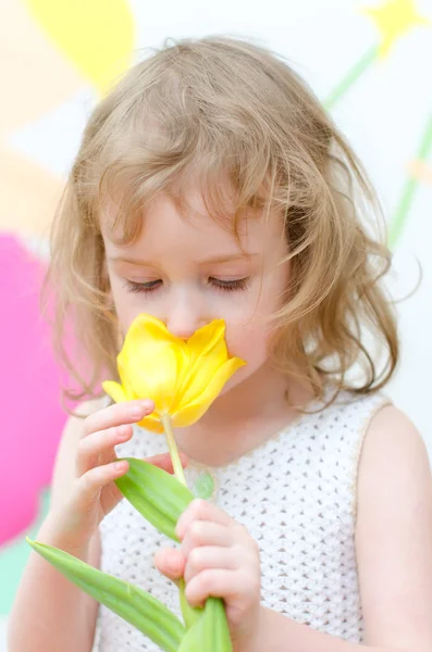 Niedliches kleines Mädchen mit gelber Tulpe — Stockfoto