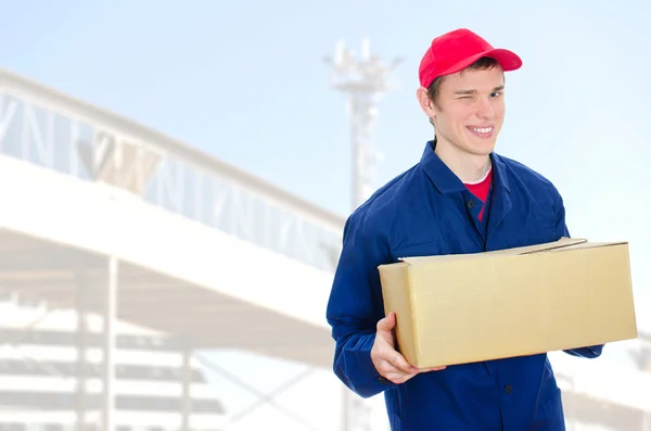 Unga leende courier hålla kartong — Stockfoto