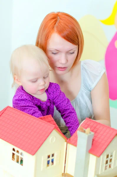 Kind en hun moeder spelen met dollhouse — Stockfoto