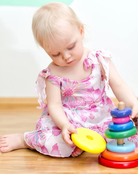 Niña jugando con colorida pirámide infantil —  Fotos de Stock
