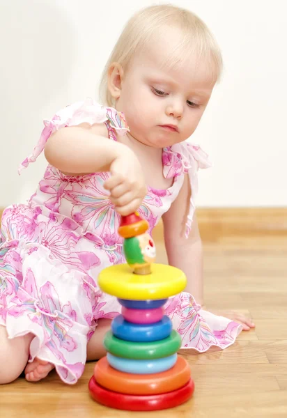 Niña jugando con colorida pirámide infantil — Foto de Stock