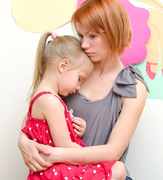 Annen üzgün çocuğunu kucaklıyor