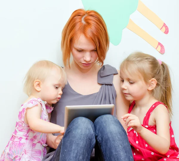 Mother and her daughters using tablet pc — Stock Photo, Image