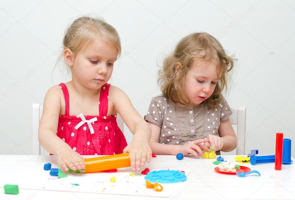 Two little girls sculpting using plasticine