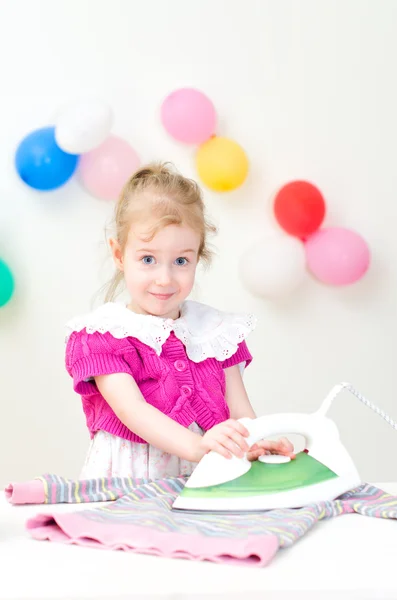 Söt liten flicka stryka kläder — Stockfoto