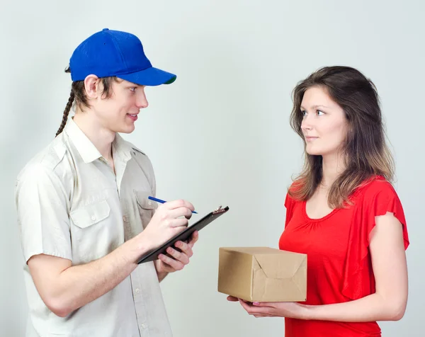 Young courier deliver package to pretty woman — Stock Photo, Image