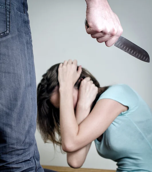 Um homem com uma faca a vir ter com a mulher. Conceito de violência doméstica — Fotografia de Stock