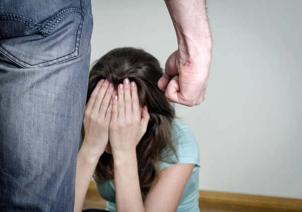 Home violence concept. Frightened woman and men's fist — Stock Photo, Image