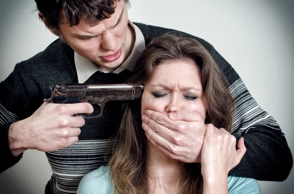 Człowiek z pistoletu zagrażają kobieta — Zdjęcie stockowe