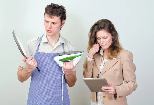 Zakenvrouw en haar echtgenoot huishoudelijk werk doen — Stockfoto