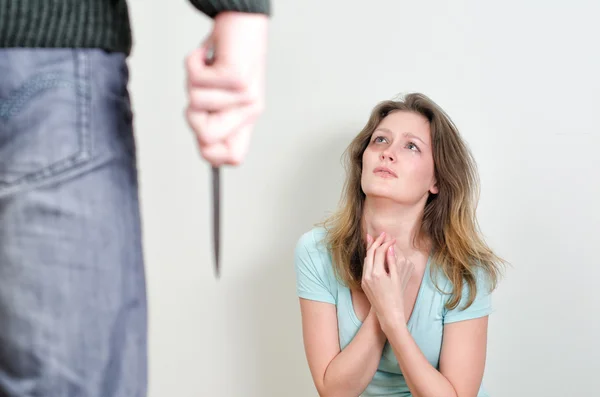 Hombre con cuchillo que viene a su esposa. Concepto de violencia doméstica — Foto de Stock