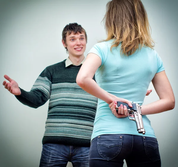 Mujer escondiendo arma bajo mano hablando con el hombre —  Fotos de Stock