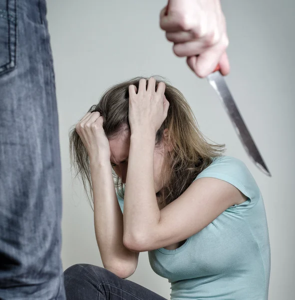 Un homme avec un couteau arrive à sa femme. Concept de violence familiale — Photo