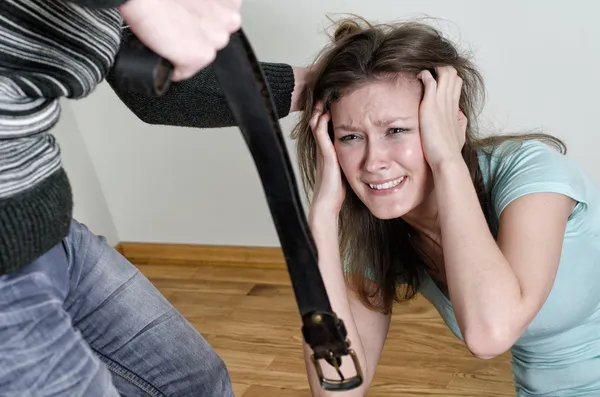 Hombre con cinturón acercándose a su esposa. Concepto de violencia doméstica —  Fotos de Stock