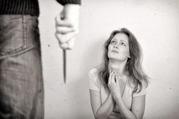 Hombre con cuchillo que viene a su esposa. Concepto de violencia doméstica. Blanco y negro —  Fotos de Stock