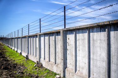 mavi gökyüzünün altında dikenli tel çit