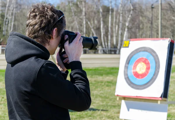 Photographer with SLR camera aims — Stock Photo, Image