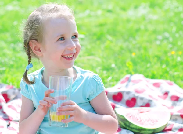微笑女孩在 th 公园喝橙汁的肖像 — 图库照片