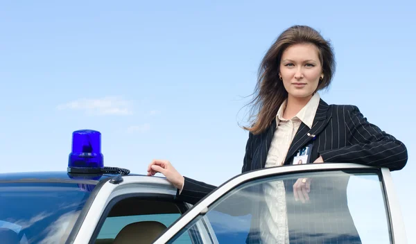 Young female FBI agent standing near car open door — Stock Photo, Image