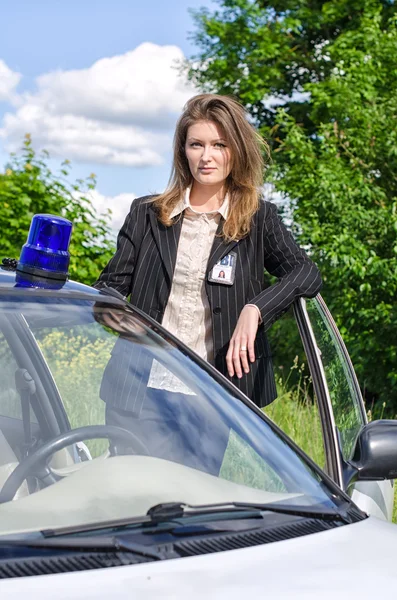 Young female FBI agent standing near car open door — Stock Photo, Image