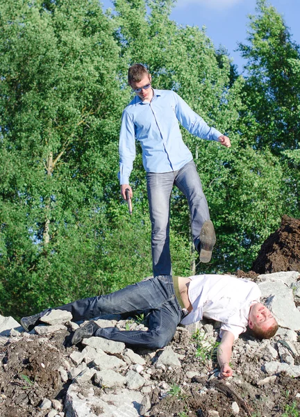 Преступник избавляется от трупа, сбрасывает со скалы — стоковое фото