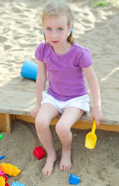 Sandbox oturan küçük kız