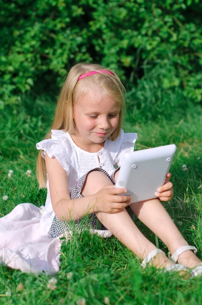 Ragazzina seduta con il computer all'aperto . — Foto Stock