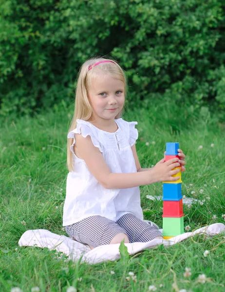 Little girl playing blocks in the park — Stock Photo, Image