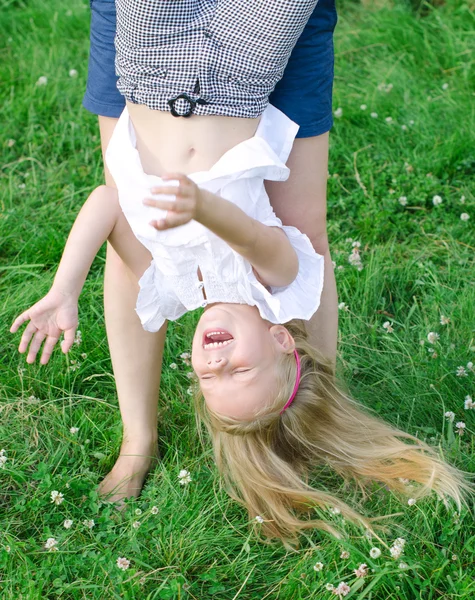 Kleines lustiges Mädchen spielt kopfüber im Freien — Stockfoto