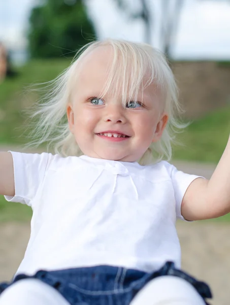 Liten flicka på gunga i parken — Stockfoto