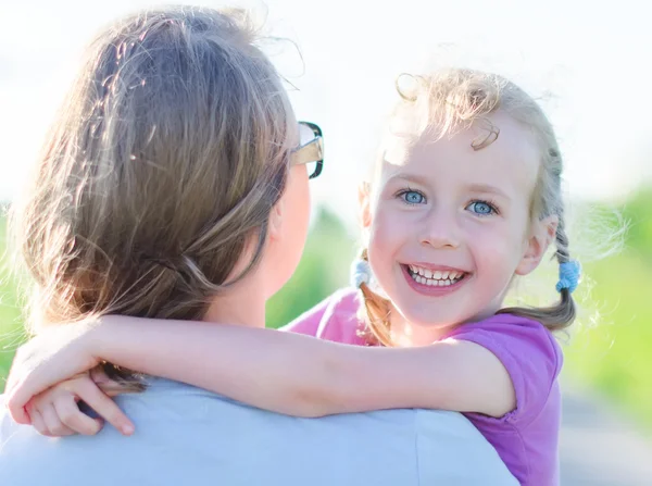 Moeder omhelst haar dochter buiten — Stockfoto