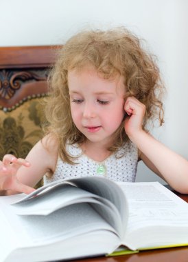 Kitap okuyan sevimli küçük kız.