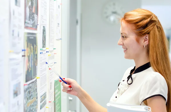 Ung kvinnlig student tittar genom jobb erbjuder ombord — Stockfoto