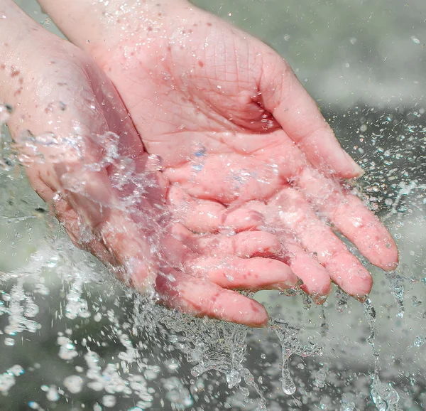 Vrouw handen met water splash buitenshuis — Stockfoto