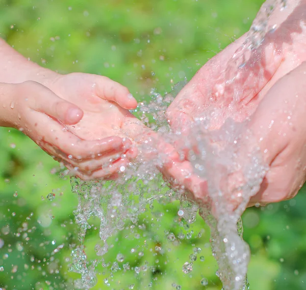 Manos de niño y mujer jugando con agua — Foto de Stock