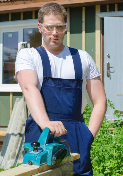 Handyman using electric planer outdoors — Stock Photo, Image