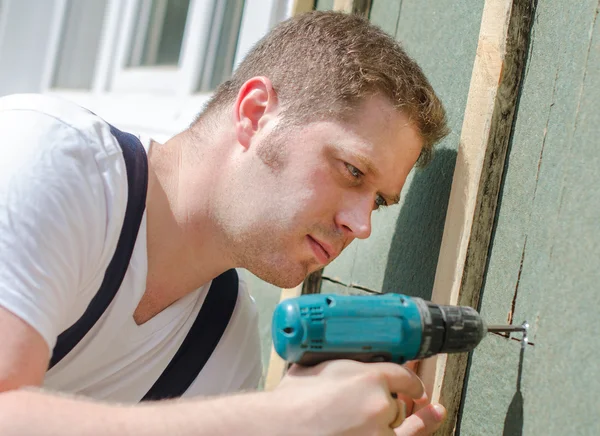 Young handsome handyman using screwdriver — Stock Photo, Image