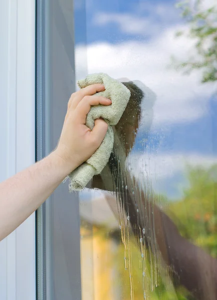 Male hand with rag washing window outdoors — Stock Photo, Image