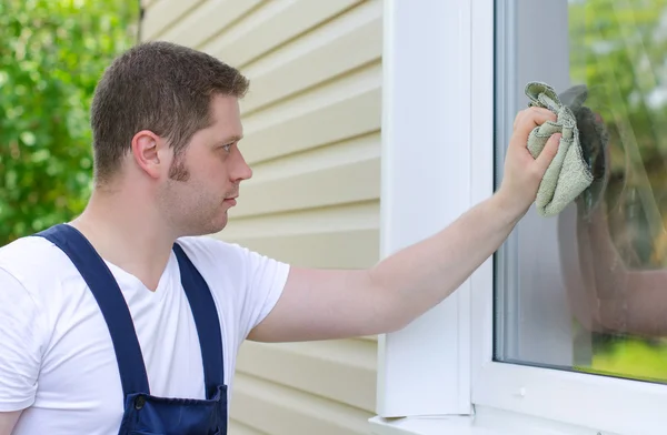 Homeworker with rag washing window outdoors — Stock Photo, Image