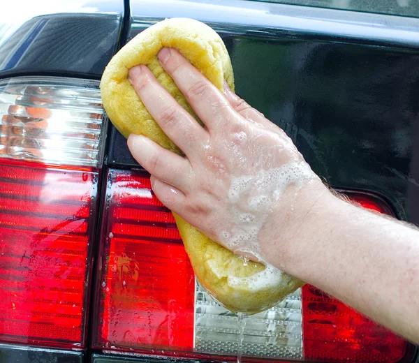 Mann wäscht Auto mit gelbem Schwamm — Stockfoto